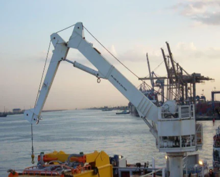 Marine deck crane beside the water with port equipment in the background