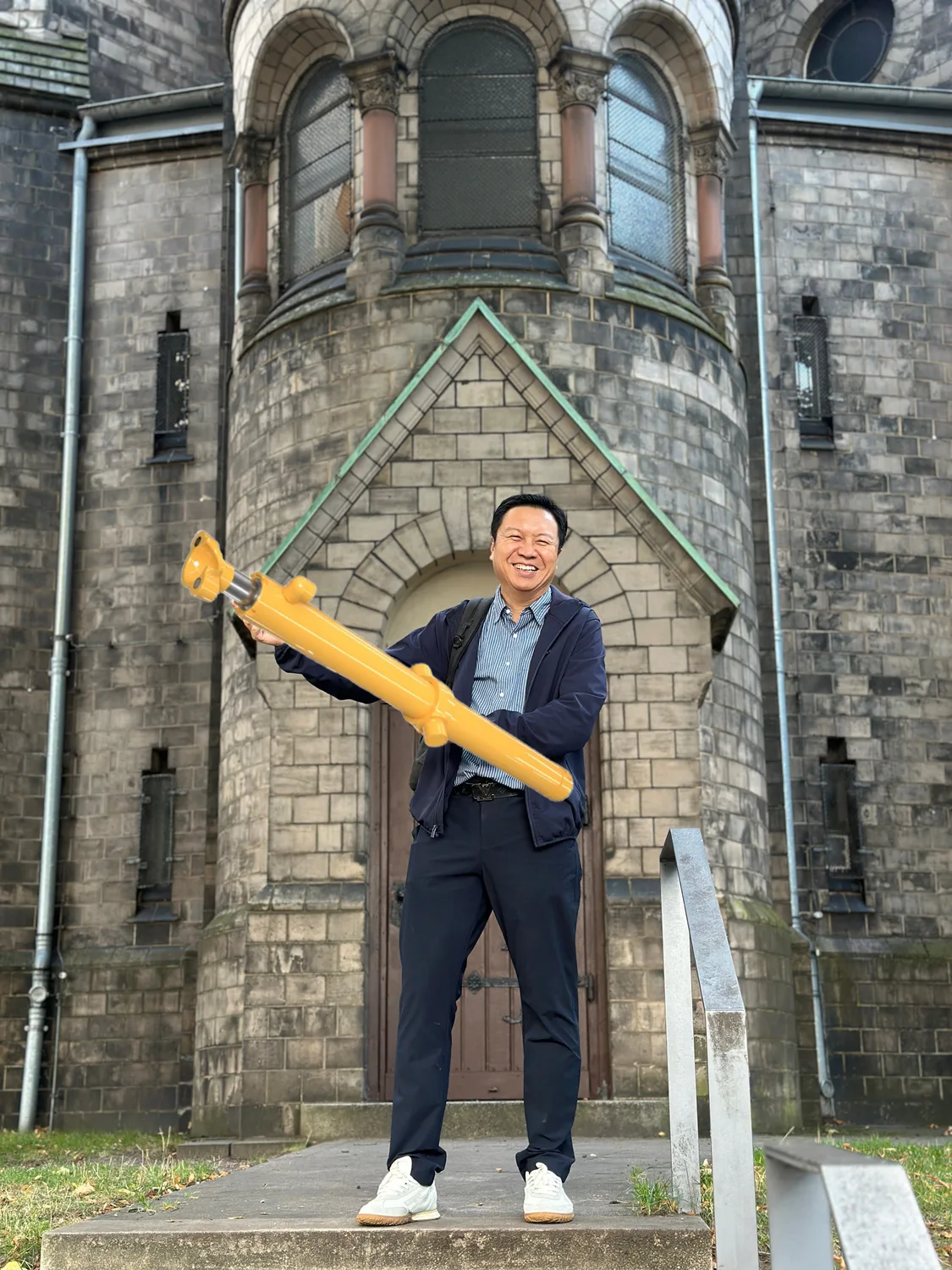 JW promotional image showing a person with a yellow cylinder graphic in front of a historic building